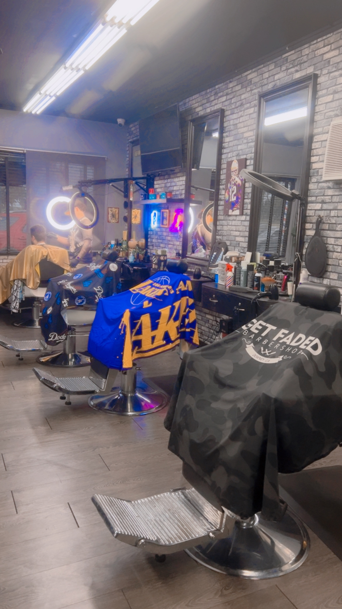 Barber chair with a Lakers cape under the ring light