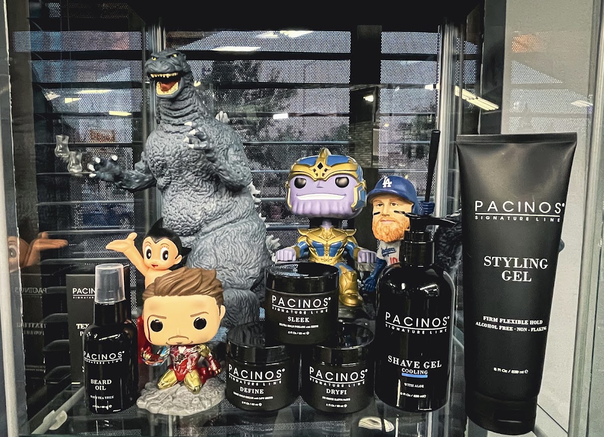 Pacinos styling products on the retail shelf beside the Godzilla and Funko cabinet