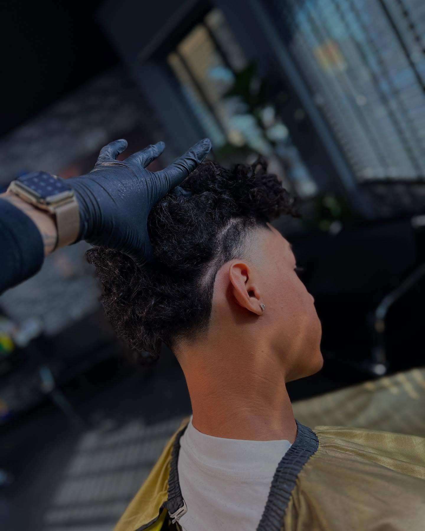 A finished cut, curly top with a clean skin fade